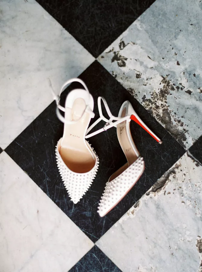White spiked Louboutin slingback shoes