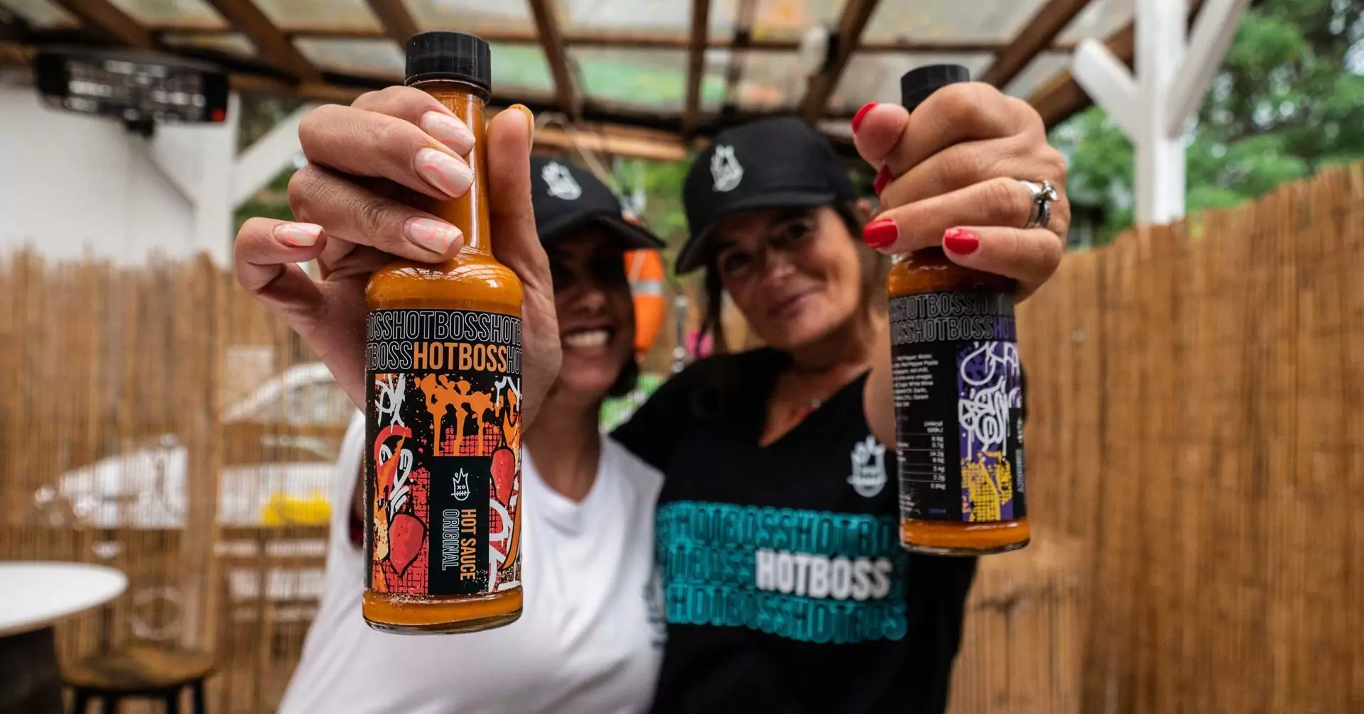 two people holding hotboss bottles