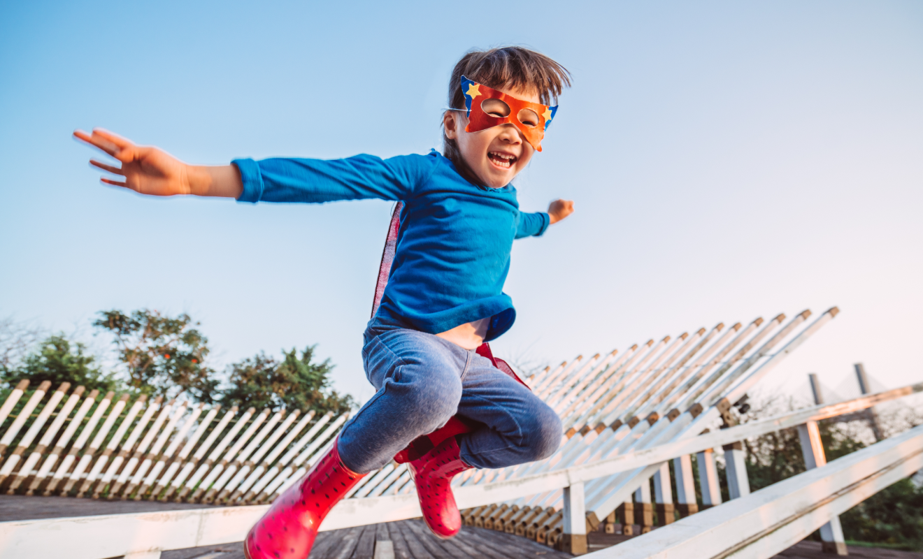 Kid dressed as super hero jumping