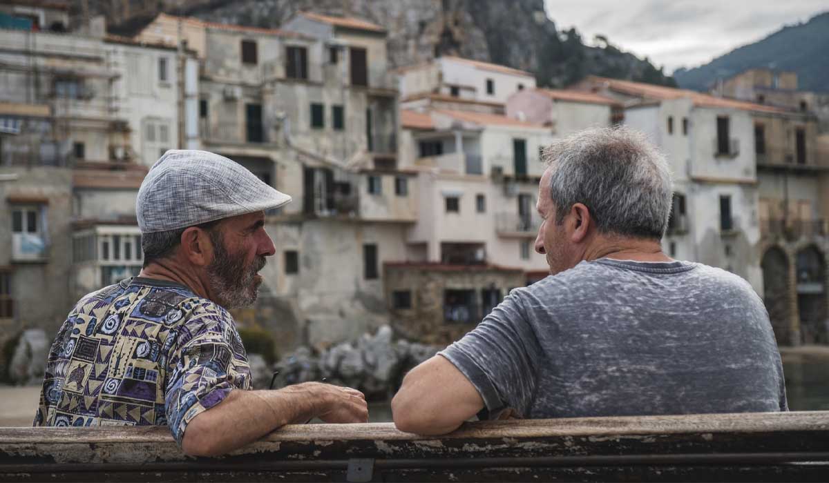 Homme sur un banc qui porte une casquette plate