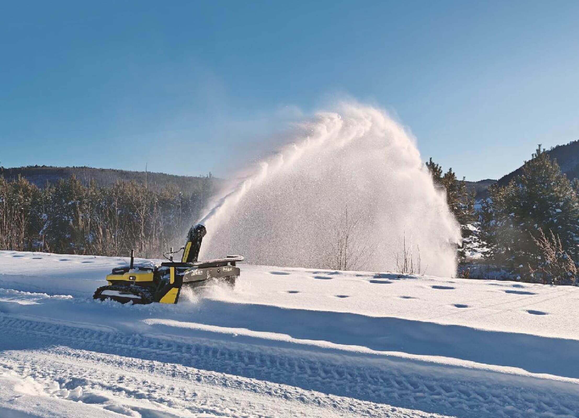 Yarbo remote-controlled snow blower showing impressive snow-throwing distance, clearing a large area.