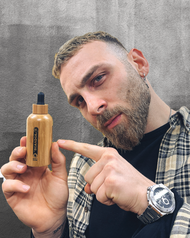 Pleasant man with well-groomed beard showing Da'Beard Oil